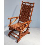 A stained beech American rocking chair, with shaped and turned back and arm rests, supported on