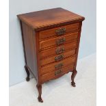 An Edwardian mahogany six drawer music cabinet, ornately engraved handles, on raised supports with