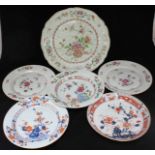 A group of six Chinese porcelain plates and bowls of varying sizes, each decorated with floral