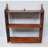 A late 18th century mahogany hanging wall shelf comprising three shelves, the sides decorated with