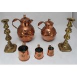 A collection of metalware items including two copper Guernsey cream jugs, three small graduated