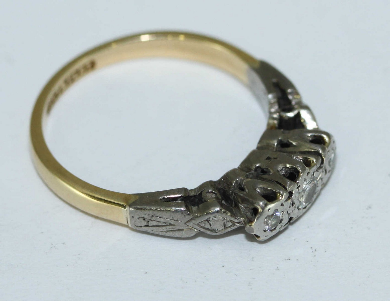 An 18ct gold and platinum three-stone illusion-set diamond ring, 2.84grms