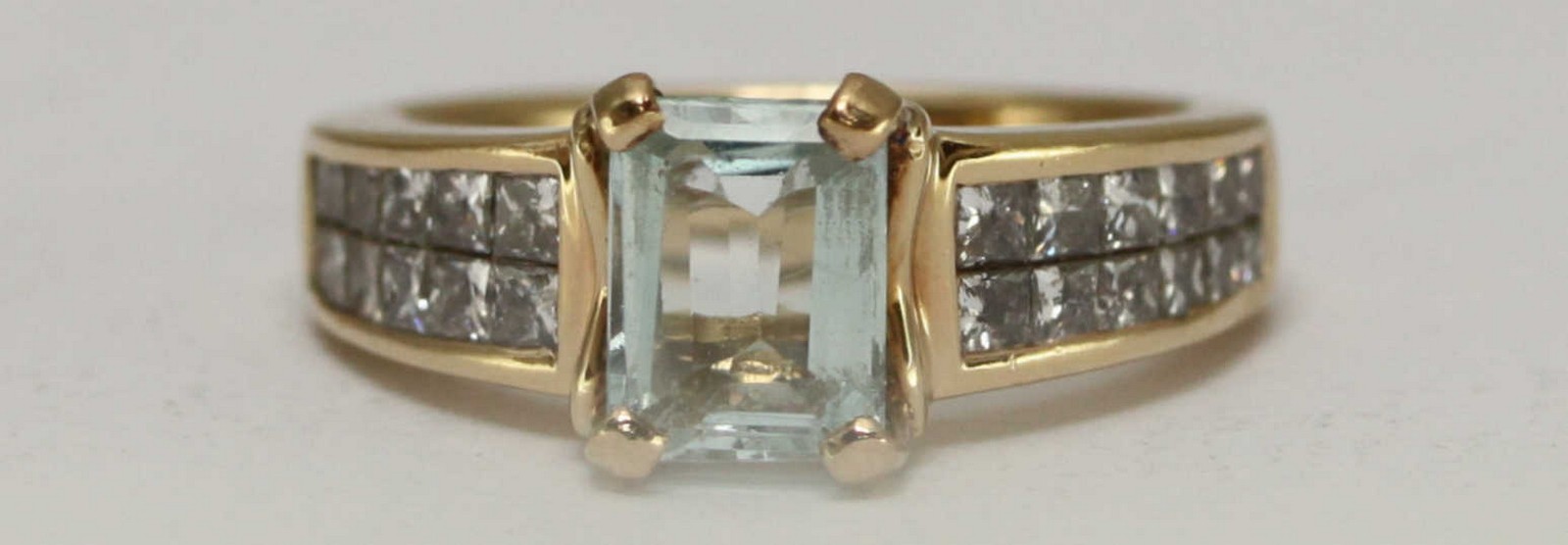 A 14 carat gold ring claw set with a central rectangular aquamarine and channel set with twenty four - Image 2 of 2