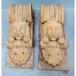 A pair of reconstituted sandstone corbels, with scrolled tops above lion masks and stylized shell