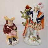 A large Staffordshire pottery figure of a huntsman with gun dog, 36cm high, together with a