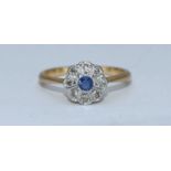 An 18ct gold, sapphire and diamond daisy cluster ring, rub-over setting, central sapphire surround