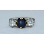 An 18ct gold sapphire and diamond ring, centrally claw-set a round faceted sapphire measuring 7.