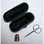 A silver sewing set by 'Touron' comprising of a pair of scissors and a thimble, housed in a fitted