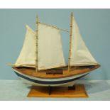 A scratch built wooden pond yacht, with planked and pinned hull and gaff style rigging, on wooden