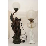 A resin figural lamp depicting a winged figure holding a maiden, together with a white porcelain,