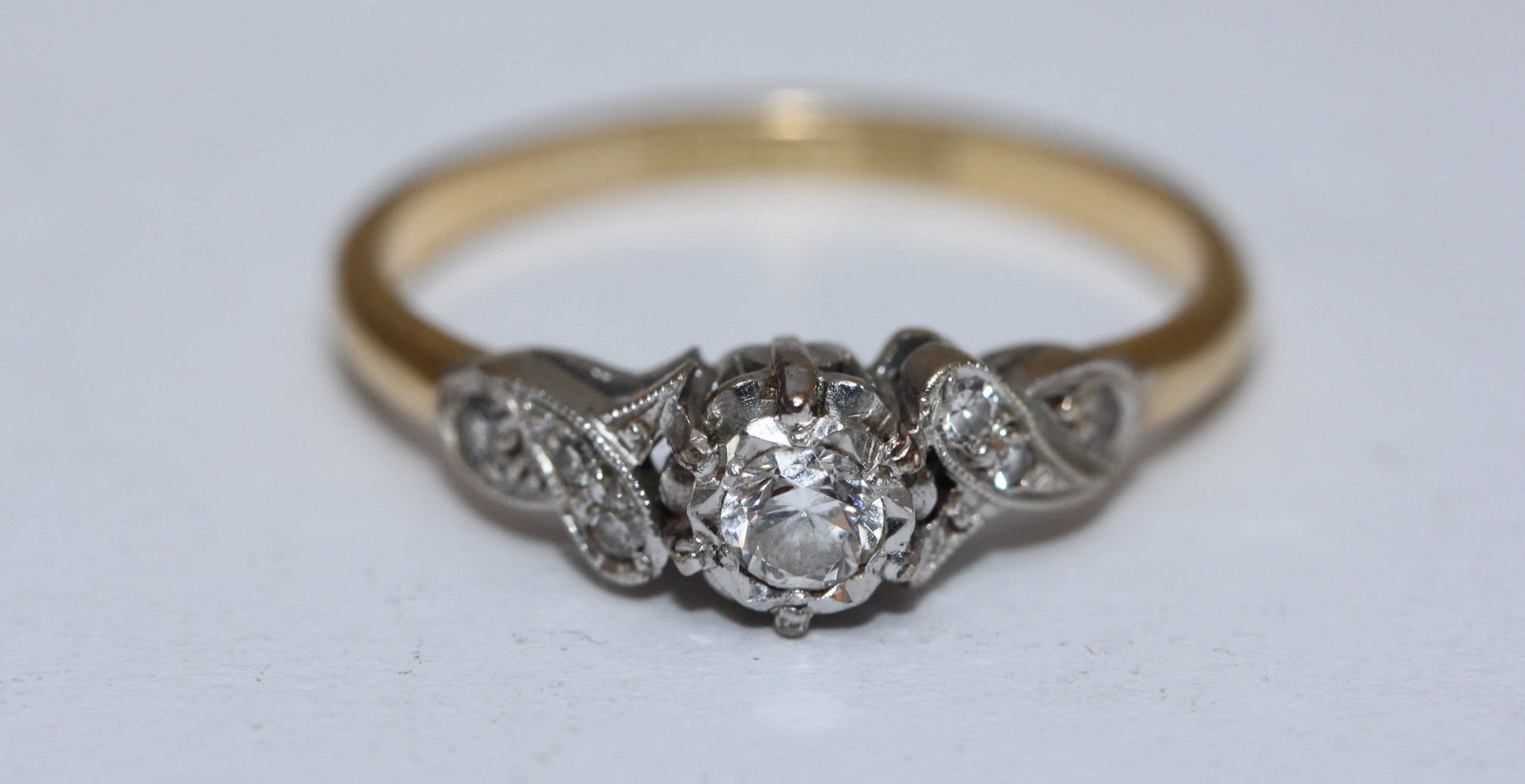 An 18ct gold and diamond ring, centrally set with a rbc diamond, measuring approximately 0.20cts,