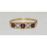 An 18 carat gold antique style ring with carved mount set with three rubies and two diamonds.