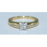 An 18ct gold diamond ring, four calibre-cut diamonds with corner claw mount, channel set to the