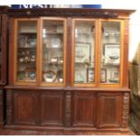 A large 19th century oak bookcase, the cornice decorated with classically carved cherubs, scrolls