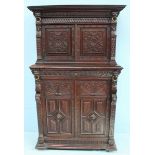 A 17th century style oak court cupboard, the shaped cornice above a pair of panelled doors enclosing