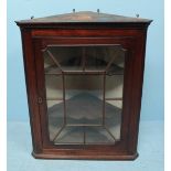 A George III oak hanging corner cupboard, with dentil moulding above a single glazed door