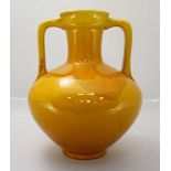 A Burmantofts Faience pottery two handled vase, model no. '1819' decorated in a yellow glaze. 26cm