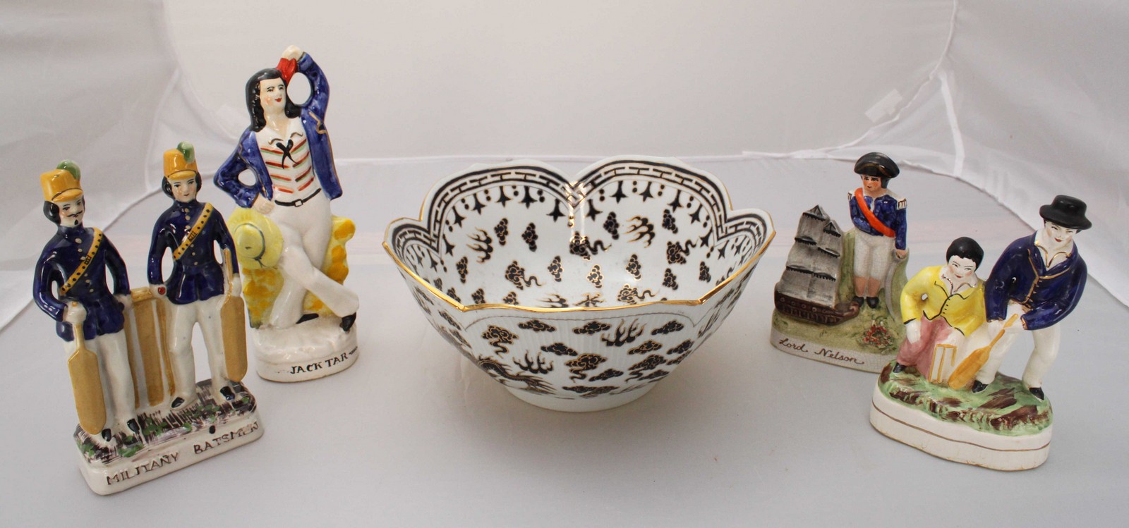 Four various Staffordshire pottery figures including 'Military Batsman' etc and an Oriental bowl