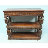 A 19th Century carved oak two-tier buffet, the middle shelf with secret drawer.