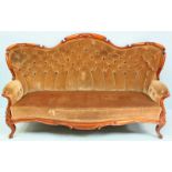 A Victorian walnut sofa, with scrolled serpentine back and green velvet upholstery, raised on