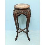 A late 19th century Chinese stained oak jardinière stand with inset, pink marble top and raised on