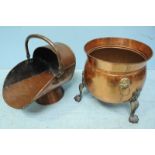 Two copper coal buckets, one with brass handles and raised on three paw feet.