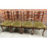 A set of four Edwardian mahogany standard chairs with pierced and carved backs, green fabric