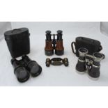 Two pairs of Dolland binoculars, a pair of Army & Navy binoculars, all leather bound and two with