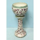 A large early 20th Century pottery jardinière and stand, decorated with a pink and purple floral