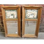 A pair of ornate gilt framed mirrors, the top sections with panels decorated with scenes of cherubs.