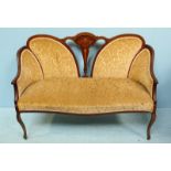 An Edwardian inlaid mahogany sofa together with two armchairs, all with gold, floral fabric