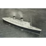 A large monochrome portrait of the cruise ship Queen Elizabeth, taken at anchor showing an aerial