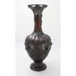 A late 19th Century Japanese patinated bronze baluster vase, cast with animal masks and birds amidst