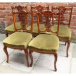 A set of five Edwardian mahogany standard chairs, with pierced and shaped backs, green fabric