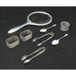 A small collection of silver items comprising of a hand mirror, three various napkin rings, two