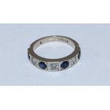 An 18ct gold, diamond and sapphire half-eternity ring, set with four round faceted sapphires and