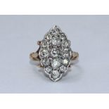 An antique diamond ring, the white-gold elliptical top set with 15 graduated Victorian Cushion-cut