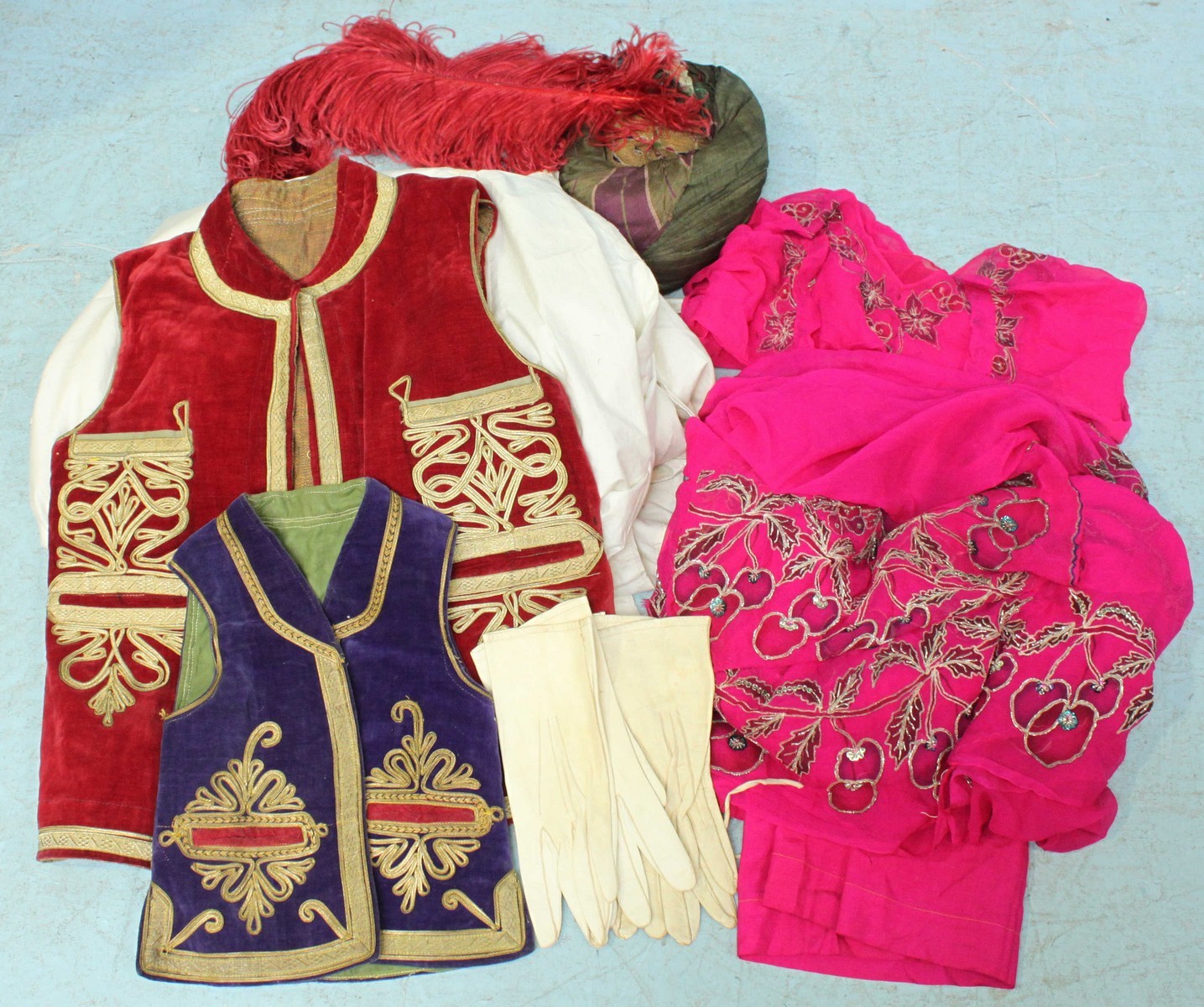 Two velvet embroidered waistcoats, pink sari, white top and trousers, traditional style hat with