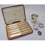 A quantity of silver items including a silver cup, a napkin ring, a caddy spoon, a brooch and a