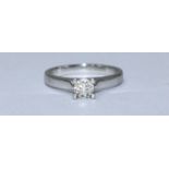 A platinum and solitaire diamond ring, four-claw set with a round brilliant cut diamond weighing