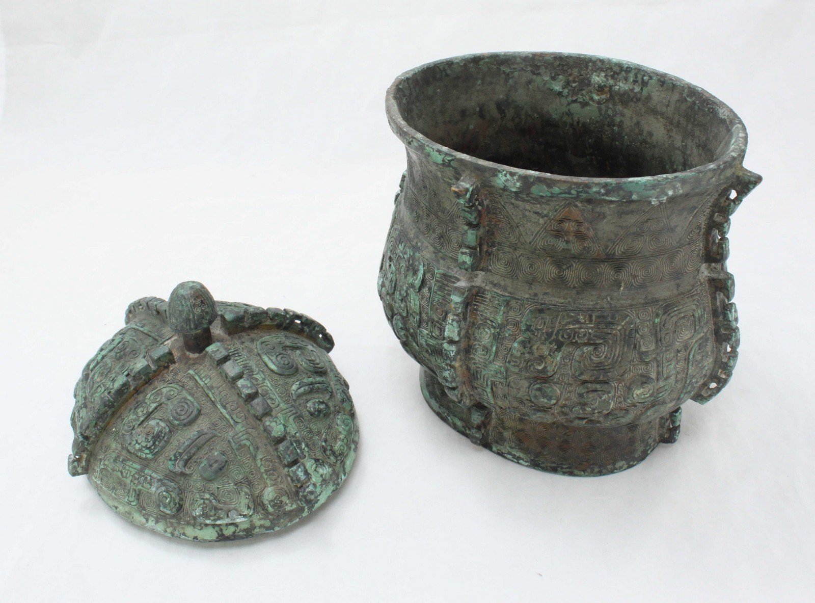 A Shang dynasty style patinated bronze ritual vessel, the underside of lid baring character marks