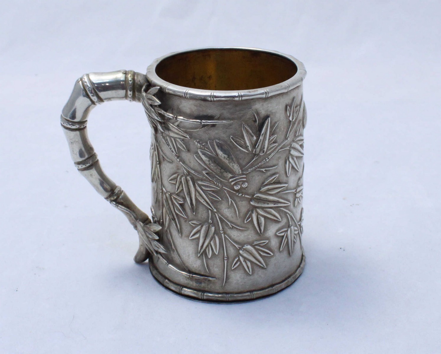 A Chinese export silver mug, Canton c.1830's, of tapered cylindrical form, with a bamboo design loop