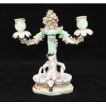 A 19th century Meissen porcelain two-light candelabrum of rustic form modelled as a flower-encrusted