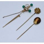 Three vintage stick pins comprising a diamond-set Maltese Cross, a sword and scabbard (both unmarked