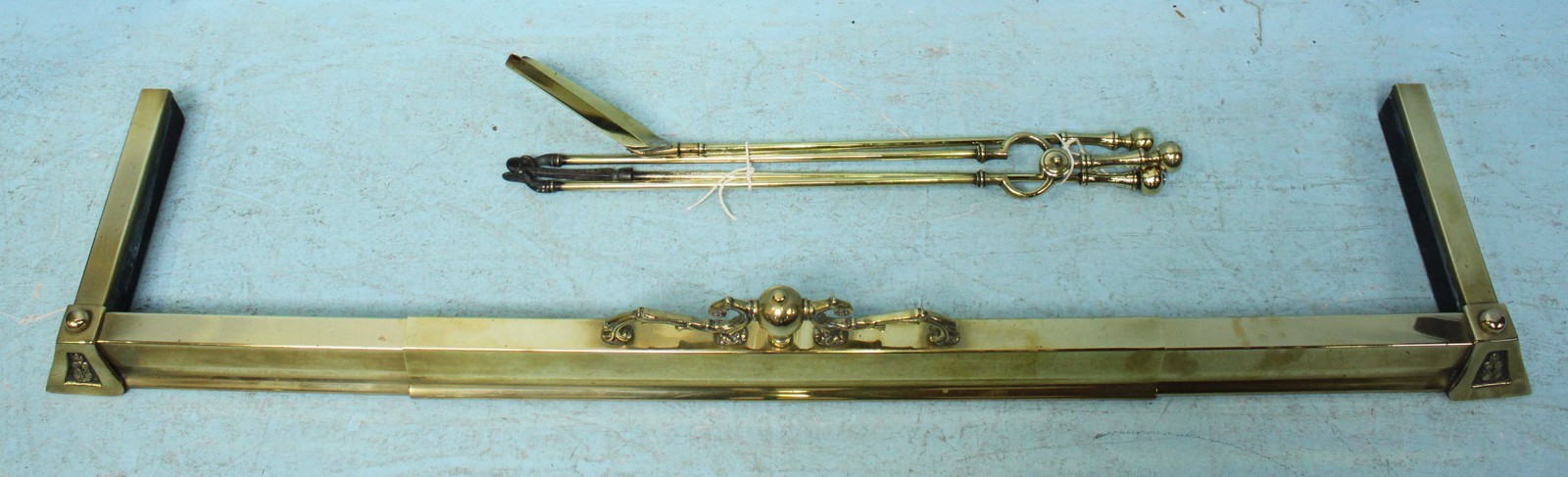 A brass fire fender and various brass fire irons.