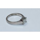 An 18ct white solitaire diamond gold ring, centrally four claw set with a princess cut diamond,