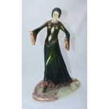 A resin figure of a 1920s flapper 'style' lady in green and gold dress, on marble base,