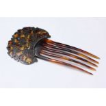 A tortoiseshell comb with silver inlaid leaf design top