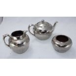 A three-piece 'silvered' pottery tea set by Gibson and Sons comprising of a teapot, jug and sugar