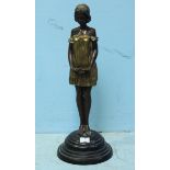 A patinated and painted bronze figure of a girl in a gold dress